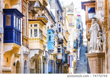 Typical narrow streets with colorful balconies in Valletta , Malta 74770749