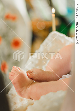 Baptism of a baby, close up of tiny baby feet, sacrament of baptism. Baptism of a baby, close up of tiny baby feet, sacrament of baptism. 74770857