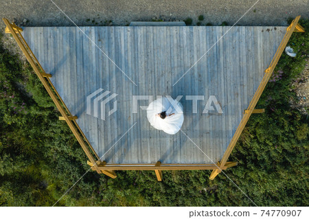 Dance of the bride in a dress on the observation deck, top view, touching moment. 74770907