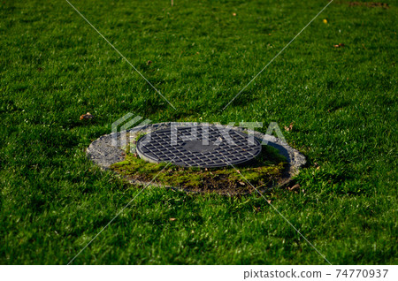 Sewer manholes in the city park, drainage system, reservoirs. Sewer manholes in the city park, drainage system, reservoirs. 74770937