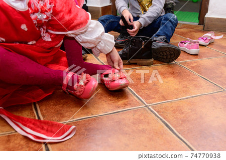 Children change their shoes to play on the playground, which is inside the room, children's room. Children change their shoes to play on the playground, which is inside the room, children's room. 74770938
