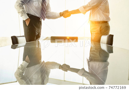 Midsection of business people shaking hands in conference room Midsection of business people shaking hands in conference room 74772169