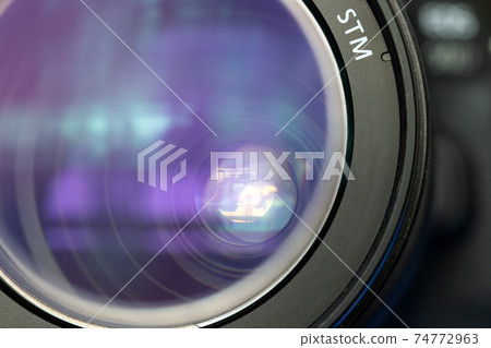 Close up lens of camera with open aperture and reflection. 74772963