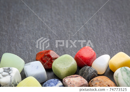 colorful gemstones on slate stone 74773525