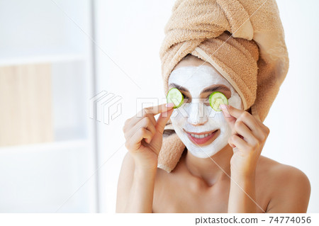 Skin care, woman with beautiful facial skin applying mask on face 74774056