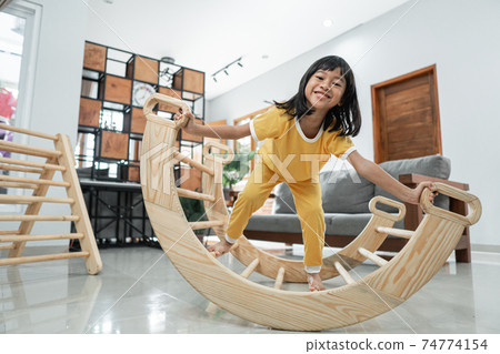 little girl smile while playing balance in pikler triangle toy little girl smile while playing balance in pikler triangle toy 74774154