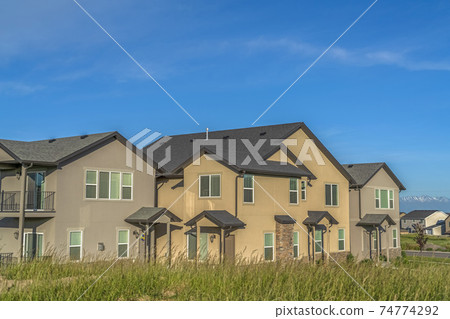 Exterior view of multi storey homes with balconies and porticos against blue sky 74774292