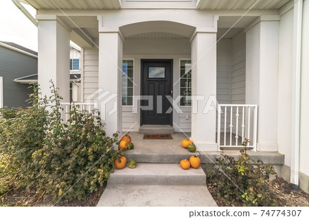 Pumpkins decorating a pathway to a house 74774307