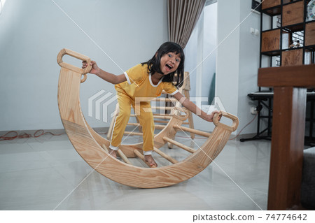 a happy girl standing on pikler balance toys a happy girl standing on pikler balance toys 74774642