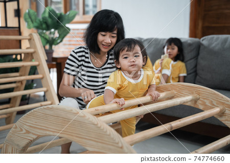 cute baby climbing pikler climbing toys with his mother cute baby climbing pikler climbing toys with his mother 74774660