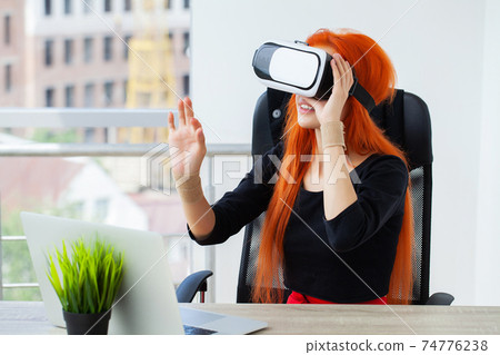 Happy young woman using a virtual reality headset Happy young woman using a virtual reality headset 74776238