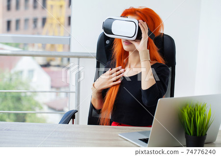 Happy young woman using a virtual reality headset Happy young woman using a virtual reality headset 74776240