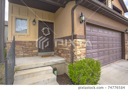 Home exterior with stairs going up to the porch and front door with wreath Home exterior with stairs going up to the porch and front door with wreath 74776584