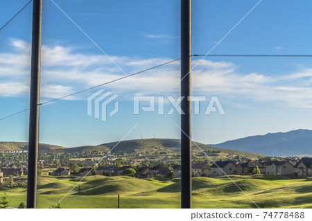 Golf course and houses on a residential area with fence in the foreground Golf course and houses on a residential area with fence in the foreground 74778488