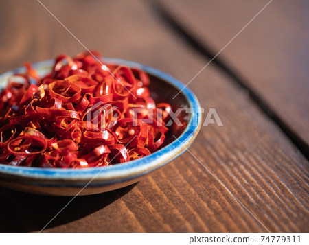 Sliced spices of bright red pepper. 74779311