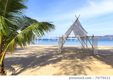Beautiful tropical beach the calm sea with cloud and sky background. Sun over tropical beach. Nature summer  concept. Bamboo and white cloth theme for camera shot on beach 74779312