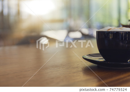 Close up hot cappuccino, latte, caramel macchiato on table with blur coffee shop background. Process with warm vintage tone style. Close up hot cappuccino, latte, caramel macchiato on table with blur coffee shop background. Process with warm vintage tone style. 74779324