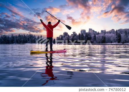 Adventurous male is paddle boarding near Stanley Park Adventurous male is paddle boarding near Stanley Park 74780012