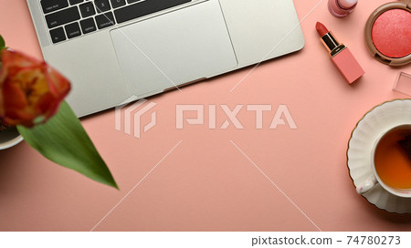 Feminine workspace with laptop, tea cup, cosmetics, flower and copy space 74780273