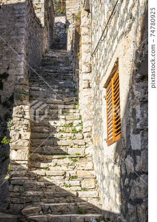 Street with stone stairs leading to the hill in Skradin town, Croatia 74780925