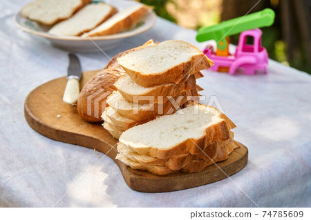 Sliced white bread on a wooden board Sliced white bread on a wooden board 74785609