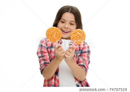 Hard choice. Girl hold two lollipops in hands isolated Hard choice. Girl hold two lollipops in hands isolated 74787529