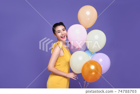 young asian woman at celebration party holding colourful balloon and smile face.  74788703