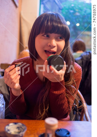 A Japanese woman with long hair who imitates eating at a cafe 74788975