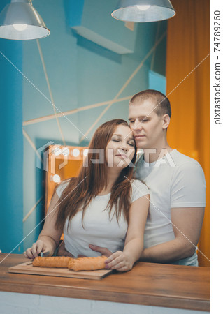 a couple in love cooking cakes. dinner at the bakery. feast in the kitchen. the butchering of the food. a woman cuts a pie with a knife 74789260