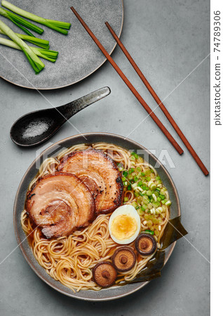 A Shoyu Ramen in gray bowl on concrete table top. Japanese cuisine meat noodle soup with chashu pork 74789306