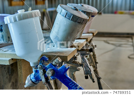 Painting chamber, spray gun. Furniture manufacture. Close-up Painting chamber, spray gun. Furniture manufacture. Close-up 74789351
