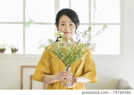 A young woman holding a vase with a codemari 74789388