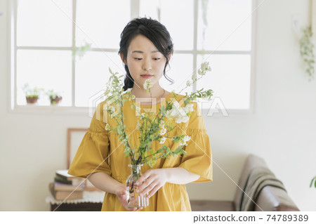 A young woman holding a vase with a codemari 74789389
