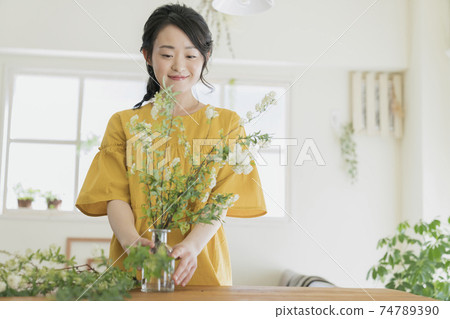 Young women decorating flowers Young women decorating flowers 74789390