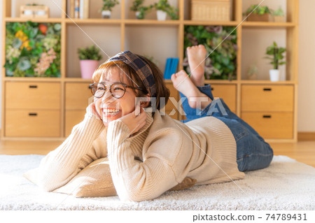 快捷的年輕女子在家裡放鬆一下 快捷的年輕女子在家裡放鬆一下 74789431