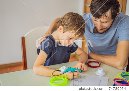 Boy and his father using 3d printing drawing pen. Creative, leisure, technology education concept 74789954
