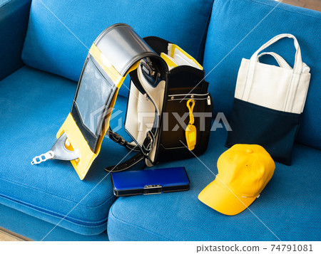 School bag and yellow hat on the sofa School bag and yellow hat on the sofa 74791081