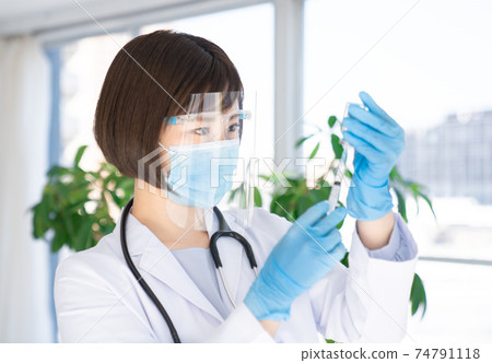 Doctor pulling vaccine from vial Doctor pulling vaccine from vial 74791118