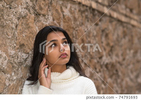 Close-up portrait of a romantic brunette girl looking upwards. Outdoors Close-up portrait of a romantic brunette girl looking upwards. Outdoors 74791693