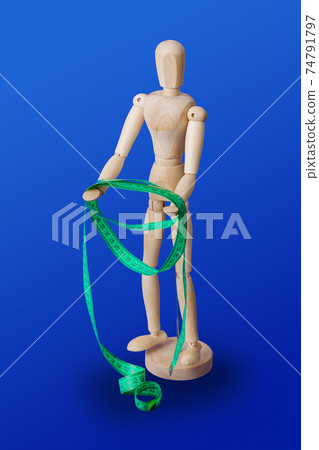 Wooden toy figure with measuring tape on blue Wooden toy figure with measuring tape on blue 74791797