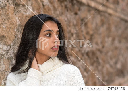 Close-up portrait of a romantic brunette girl looking aside. Outdoors Close-up portrait of a romantic brunette girl looking aside. Outdoors 74792458