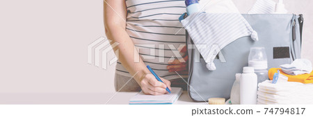 Woman packing diaper bag in maternity hospital. 74794817