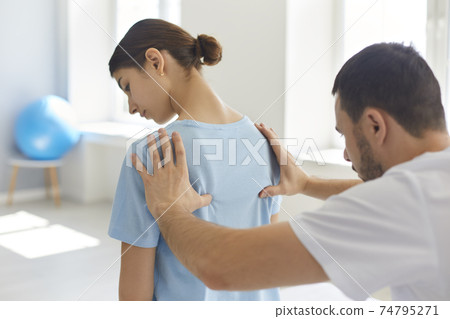 Young woman getting procedure of fixing joints and acupuncture from chiropractor 74795271
