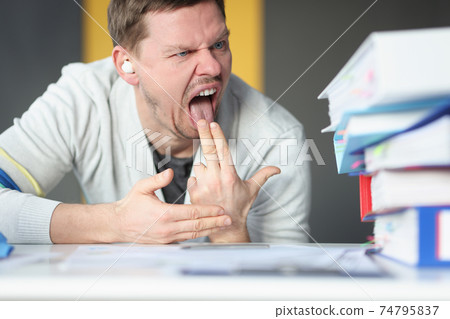 Man looking at folders with documents and putting two fingers in his mouth 74795837