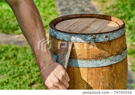 Oak Barrel. Opening the barrel with a chisel and hammer Oak Barrel. Opening the barrel with a chisel and hammer 74795916