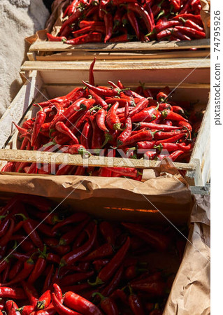 Red hot chili pepper in wooden boxes under the sun Red hot chili pepper in wooden boxes under the sun 74795926