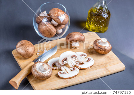 Parisian champignons, chopped mushrooms on wooden chopping board Parisian champignons, chopped mushrooms on wooden chopping board 74797150