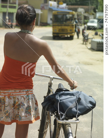Woman Walking With Bicycle On Street Woman Walking With Bicycle On Street 74797990