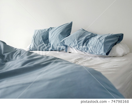 Unmade Bed With Crumpled Blue Bed Linens 74798168