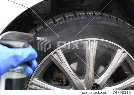在臟輪胎上噴塗清潔劑 在臟輪胎上噴塗清潔劑 74798316